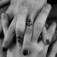 Tiny black anchors for sweethearts tattoo on ring fingers