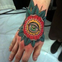 Tatuaje en la mano,  flor extraño con ojo verde