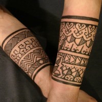 Tatuajes en los antebrazos,
brazaletes ornamentados negros