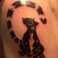 Tribal black-ink lemur tattoo on upper arm