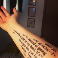 Unusual bird-shaped printed quote tattoo on arm