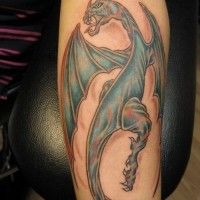 Unusual blue-colored dragon tattoo on forearm