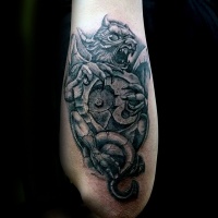 Usual tatuaje exacto del brazo pintado de la estatua de la gárgola con el símbolo de piedra Yin Ynag
