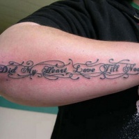 Tatuaje en el antebrazo, inscripción larga con letra pequeña