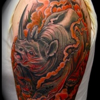 Tatuaje en el brazo,
rinoceronte imponente en el humo rojo