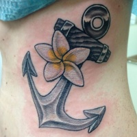 Tatuaje en el costado, ancla gris grande con flor tierno