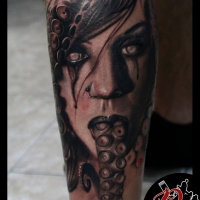 Woman face and tentacles tattoo on forearm