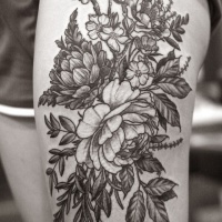 Tatuaje en el muslo,  planta con flores descolorida