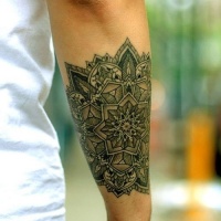 Wonderful uncolored flower mandala tattoo on forearm