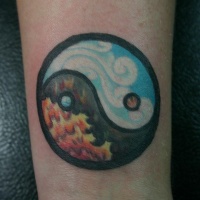 Tatuaggio colorato sul braccio il disegno in stile Yin-Yang
