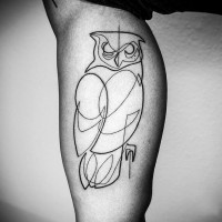 Abstract style black ink owl shaped tattoo on arm