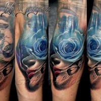 Abstract style colored arm tattoo of human face with blue rose