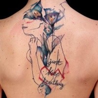 Abstrakter Stil gefärbtes Rücken Tattoo von Frau wie Silhouette mit Blumen und Schriftzug