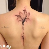 Abstract style colored big flower tattoo on back stylized with lettering