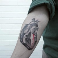 Abstrakter Stil farbiges Unterarm Tattoo mit menschlichem Herzen