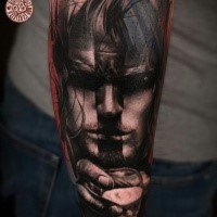 Abstract style colored forearm tattoo of human face