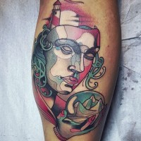 Abstract style colored mask with lighthouse and orb tattoo on leg