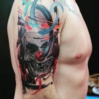 Abstract style colored shoulder tattoo of creepy clown skull