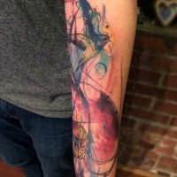 Abstract style multicolored bird with flower tattoo on arm