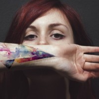 Abstract style multicolored ornament tattoo on wrist