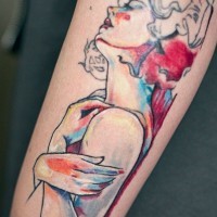 Abstract style watercolor like colored woman tattoo on arm
