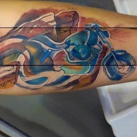 Abstract style watercolor like little bike tattoo on arm