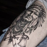 Tatuaje en el muslo, indio anciano con  hachas cruzadas
