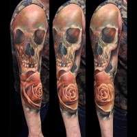 Accurate lifelike colored human skull tattoo on sleeve with realistic rose