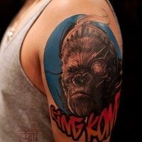 Akkurat aussehendes farbiges Affen Porträt Tattoo an der Schulter mit Schriftzug