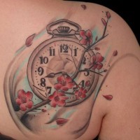 Accurate painted and colored little clock tattoo on back with blooming tree