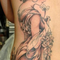 Akkurat bemaltes und gefärbtes Tattoo am halben Rücken mit der netten Frau mit Blumen und Kreuz