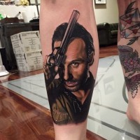 Accurate very detailed man with gun portrait tattoo on leg