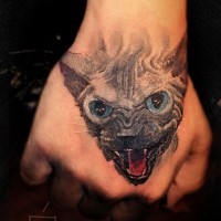 Tattoo mit aggressivem schwarzem Kater an der Hand