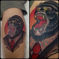 Tatuaggio colorato sulla gamba la testa di gorilla con la bocca spalancata