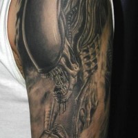 Alien from outer space and skull tattoo on shoulder
