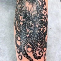 Alien like black and white very detailed octopus tattoo on arm