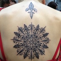 Amazing black pattern consisting of fleur de lis tattoo on back