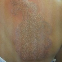 stupefacente pizzo inchiostro bianco tatuaggio sulla schiena