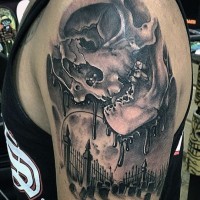 Amazing black and white corrupted human skull tattoo on shoulder combined with dark cemetery