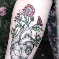 Tatuaje en el antebrazo, corazón gris con flores de color
