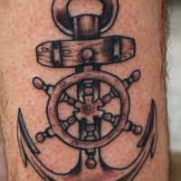 Amazing gray-ink anchor with wheel tattoo for guys on forearm
