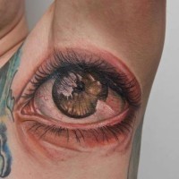 Tatuaje en la axila, ojo verde realista