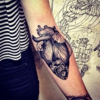 Amazing womens gray half heart-half fish tattoo on forearm