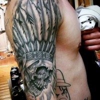 Tatuaje en el brazo, cráneo de un indio en sombrero de plumas