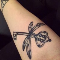 Tatuaje en el antebrazo,
 llave preciosa con alas de libélula