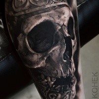Ancient like detailed leg tattoo of human skull stylized with ornaments by Eliot Kohek