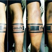 Ancient looking black ink arm tattoo with lettering