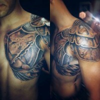 Ancient warrior armor detailed tattoo on shoulder and chest with lettering