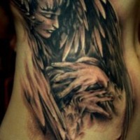 Tatuaggio grande sul fianco l'angelo con le mani ali