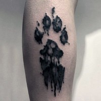 Tatuaje en la pierna,
huella negra de perro